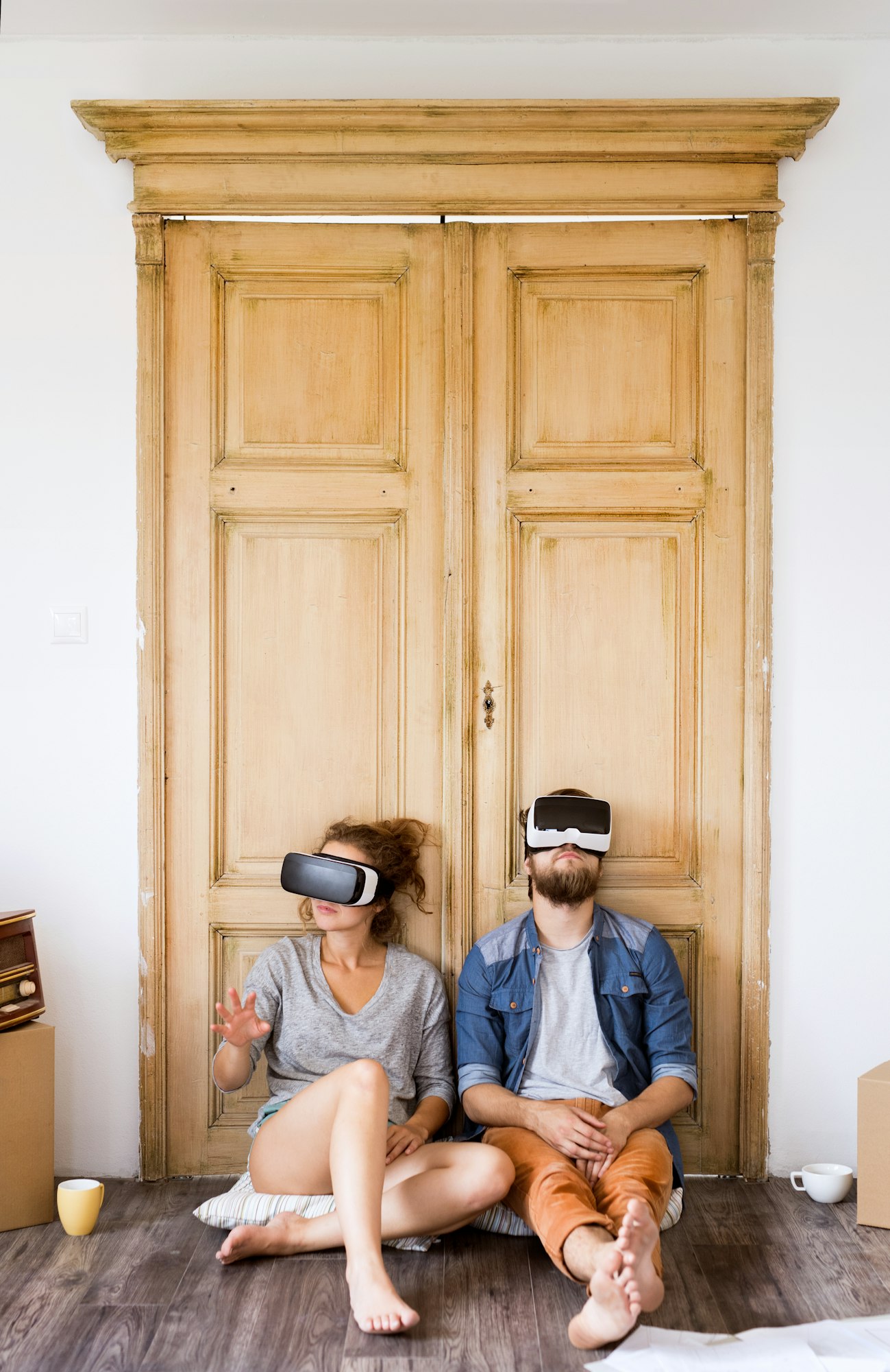 Young couple wir VR glasses moving in new house.